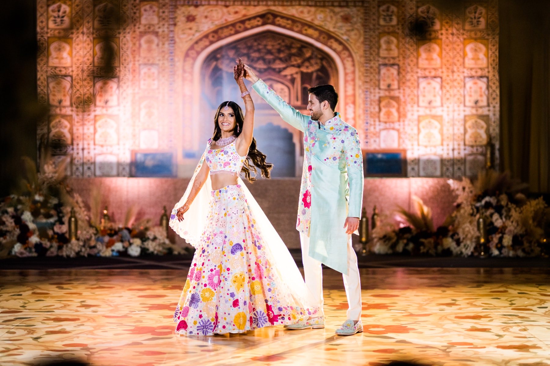 Couple spinning together at a sangeet celebration